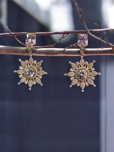 IXXIA Jewelry gold and silver-toned starburst drop earrings with clear gemstones and rectangular studs.