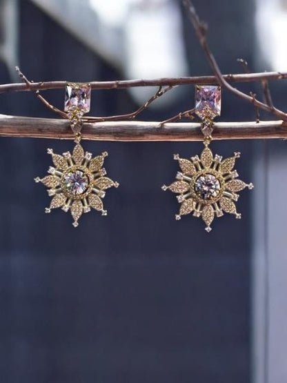 IXXIA Jewelry gold and silver-toned starburst drop earrings with clear gemstones and rectangular studs.
