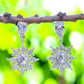 IXXIA Jewelry radiant starburst drop earrings with rectangular stud, clear gemstones, and silver-toned metal.