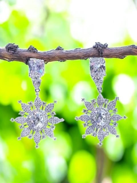 IXXIA Jewelry radiant starburst drop earrings with rectangular stud, clear gemstones, and silver-toned metal.
