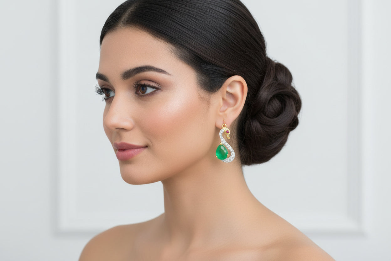 A pair of swan-shaped dangle earrings with green and gold color accents